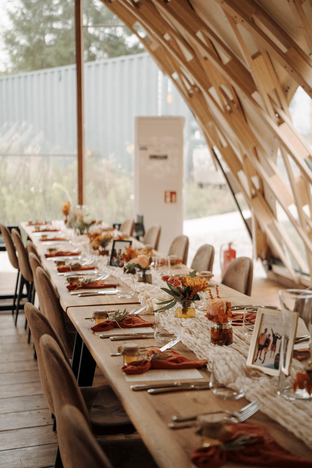 Lange, herbstlich dekorierte Hochzeitstafel unter dem Zeltdach