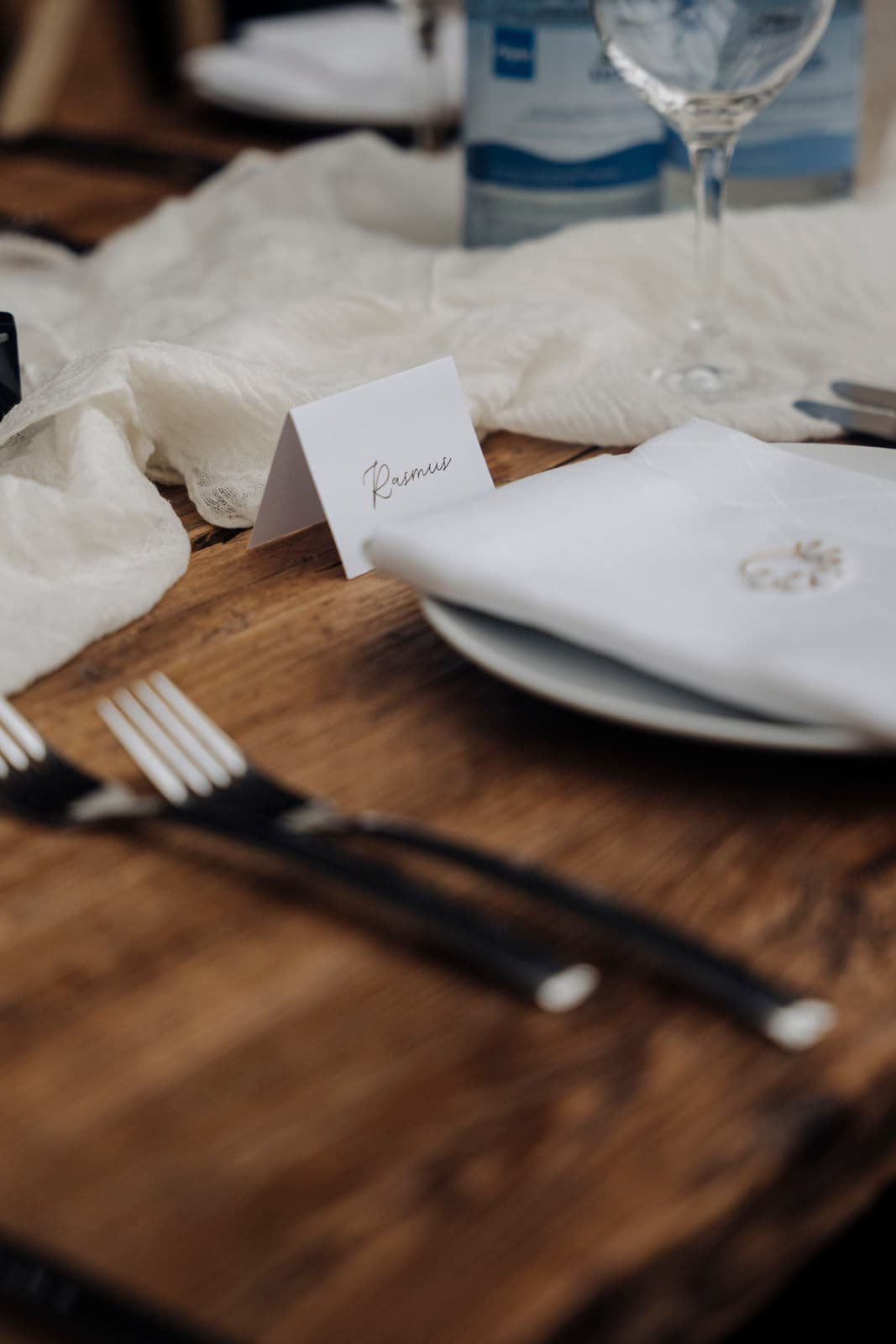 Detail einer kalligrafierten Platzkarte neben dem Gedeck mit gefalteter Serviette