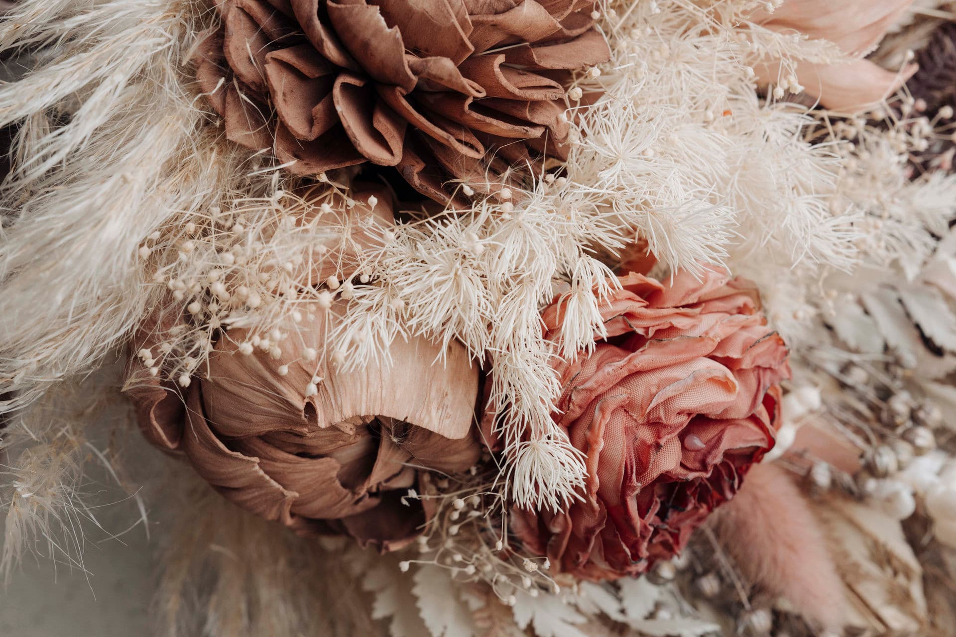 Nahaufnahme des Trockenblumenstraußes mit Holzblüten, Schleierkraut und einer roséfarbenen Rose
